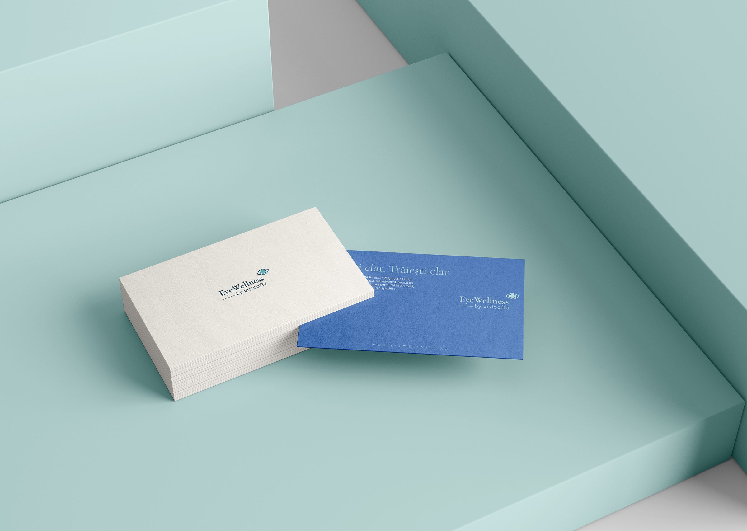 EyeWellness by Visioofta white and blue business cards on a mint green surface