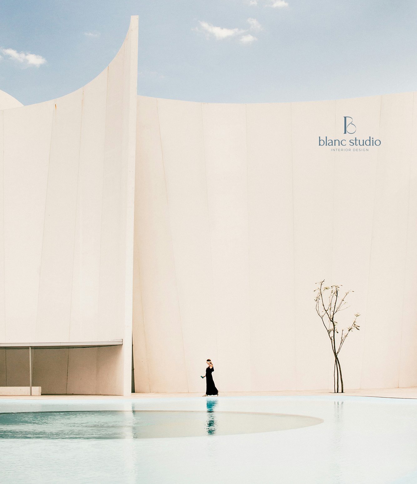 Blanc Studio logo on a pale architectural wall beside a reflecting pool